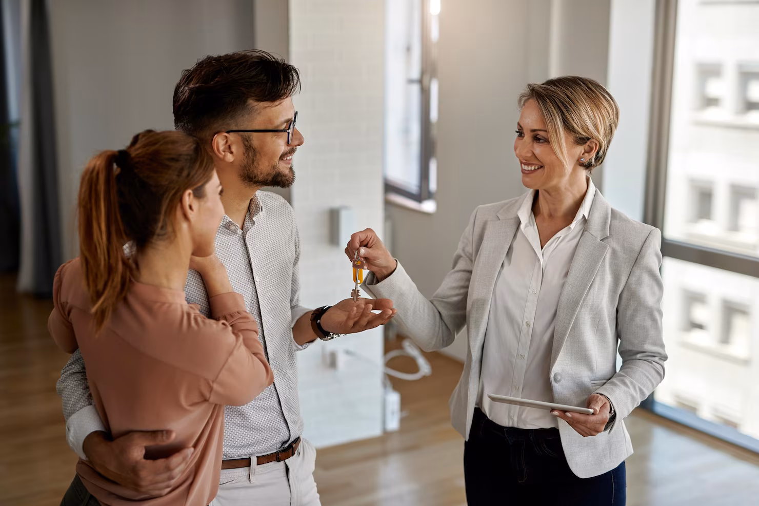 agente-inmobiliario-feliz-dando-llaves-pareja-que-esta-comprando-su-nuevo-hogar